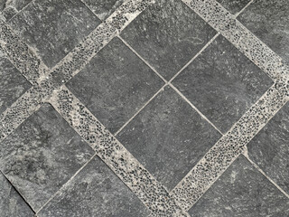 Pebbledash or roughcast coral stones in grey colors with stone tiles in diamond pattern. Random cut...
