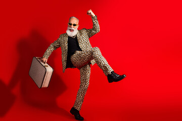 Eccentric bearded man in leopard suit celebrating his unique and bold style in a red background...