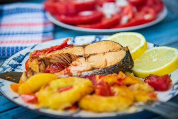 The best recipe of salmon baked with vegetables and lemon on a wooden table