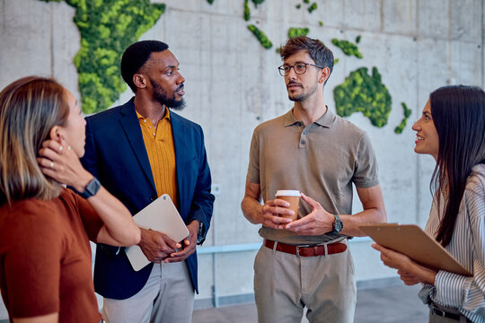 International businesspeople discussing global strategy in a modern office with a green world map made of moss