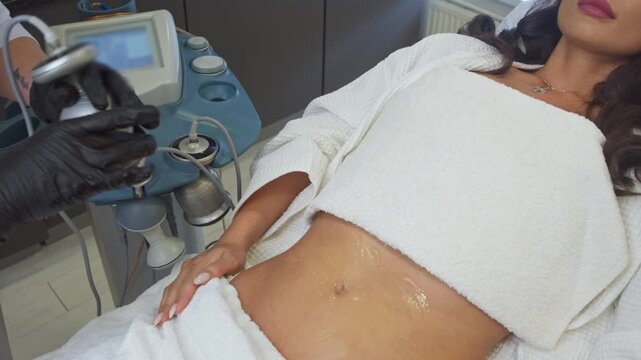 Cosmetologist at hardware medicine clinic selects necessary devices to work with excess weight and cellulite by using ultrasound.