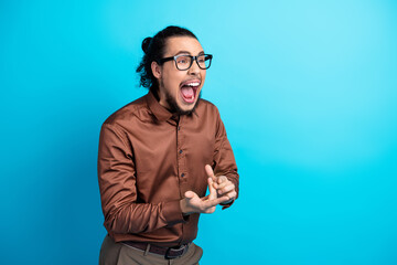 Young man in formalwear expressing excitement against a turquoise background
