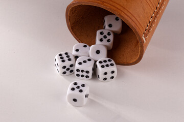 A random arrangement of dice and a puzzle cup, captured after the dice have been cast.