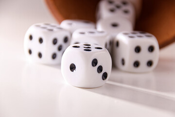 A random arrangement of dice and a puzzle cup, captured after the dice have been cast.