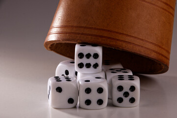 A random arrangement of dice and a puzzle cup, captured after the dice have been cast.