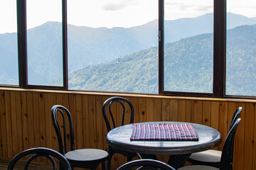 Table, chairs and window with view of Himalayan mountains outside. Sikkim, West Bengal, India.