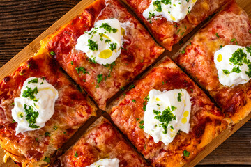 Pizza al metro margherita with burrata cheese on wooden table