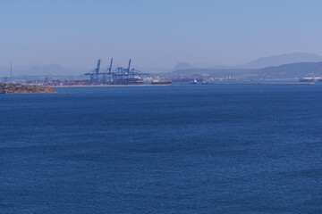 Load boat and cranes in the industrial port of Algeciras that dominates the coastal landscape