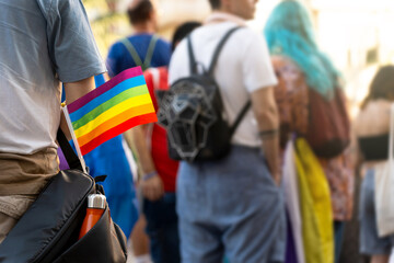 Lgbt people marching with rainbow flag at pride parade