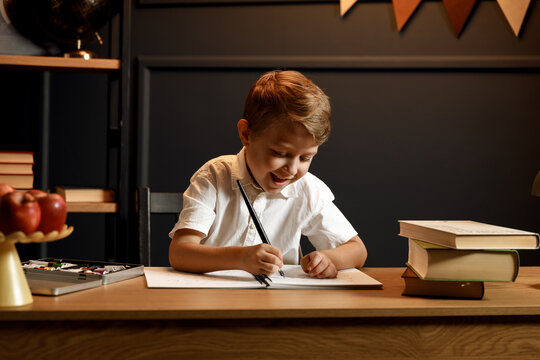 Child Doing Homework with Books and Globe &ndash; Back to School Theme
