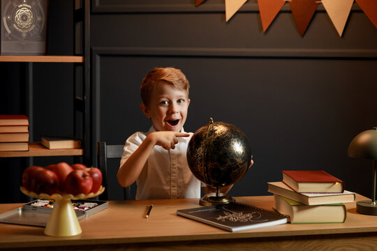 Child Doing Homework with Books and Globe &ndash; Back to School Theme