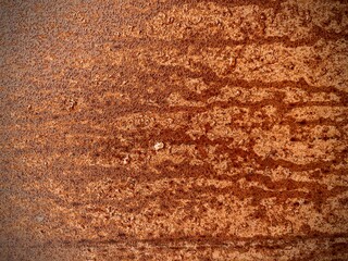 Close-up of a rusty metal surface with textured patterns and rich shades of brown and orange. Ideal for industrial, grunge, or decay-themed backgrounds and design projects.