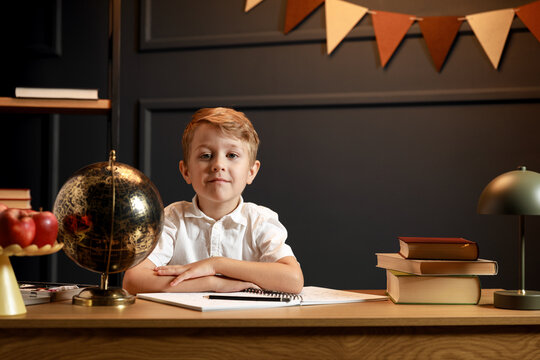 Child Doing Homework with Books and Globe &ndash; Back to School Theme