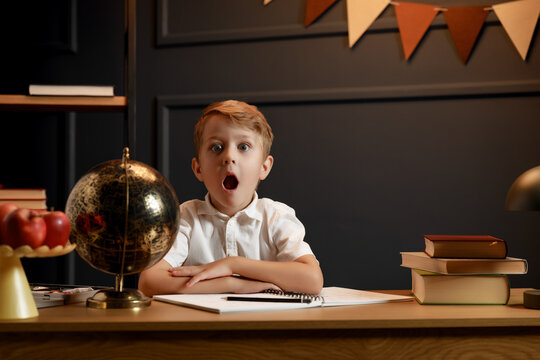 Child Doing Homework with Books and Globe &ndash; Back to School Theme