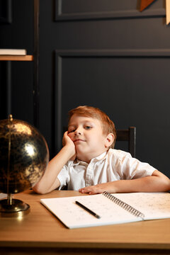 Child Doing Homework with Books and Globe &ndash; Back to School Theme