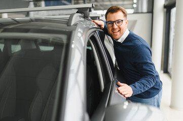 I got a new car today. Portrait of a happy mature man smiling posing near his new car at the local...