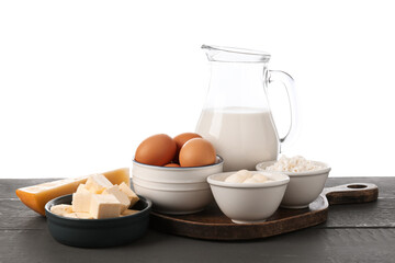Different dairy products and eggs on grey wooden table against white background
