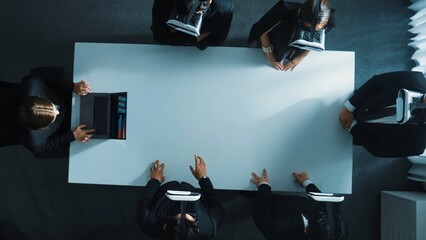 Top down aerial view of diverse data analysts wearing VR headset and stand around table while using...