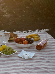 Rustic Picnic Setup with Fruits and Wine Outdoors