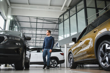 I got a new car today. Portrait of a happy mature man smiling posing near his new car at the local...