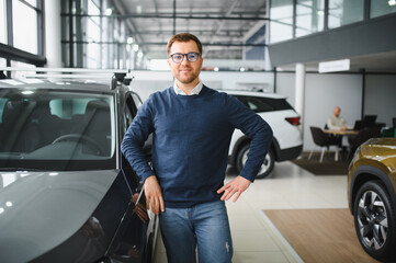 Young man is choosing a new vehicle in car dealership