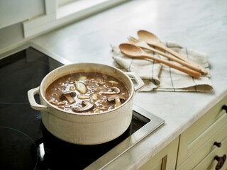 Hearty mushroom soup simmering in a dutch oven on a stovetop