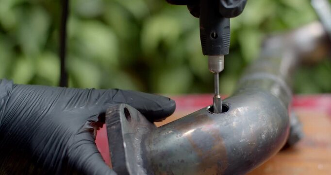 Grinding the edge of a pipe to widen the hole and make space for welding an O2 sensor adapter securely.