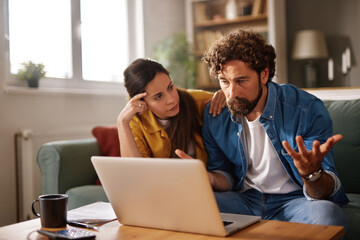 A man with curly hair and a woman with long hair engage in a serious conversation about financial...