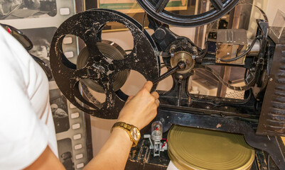 Woman examining vintage film projector. Retro