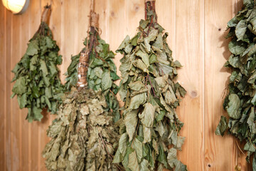 Dry birch and oak brooms in the bath are hanging on the wall. 