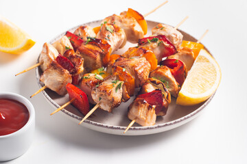 Delicious grilled chicken skewers with capsicum, lemon, salad and ketchup on a plate over the table. Chicken kebab. Healthy food concept.