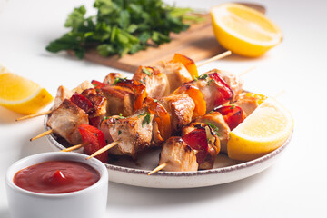 Delicious grilled chicken skewers with capsicum, lemon, salad and ketchup on a plate over the table. Chicken kebab. Healthy food concept.