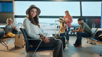 Tourist waiting at the airport gate sitting comfortably while other passengers stand