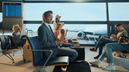 Businessman using smartphone in airport lounge waiting for flight departure