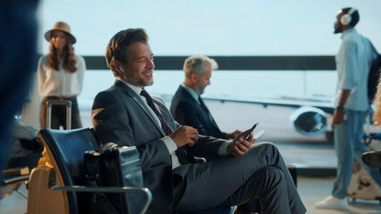 Businessman listening music and using smartphone in airport lounge