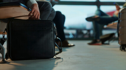 Businessman picking up briefcase in airport lounge