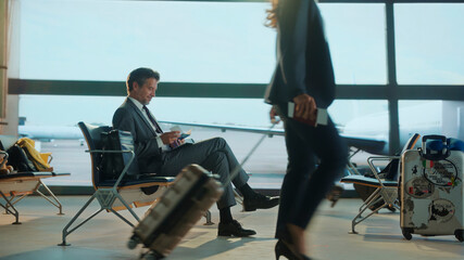 Businessman waiting in airport lounge checking tickets and passport
