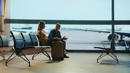 Passengers waiting in airport lounge discussing travel plans