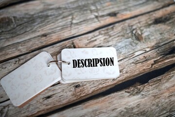 DESCRIPSION, text on a small notebook isolated on a wooden table.