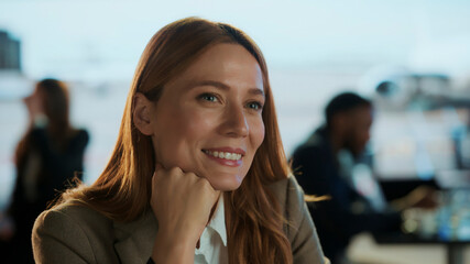 Businesswoman smiling in airport business lounge waiting for flight departure