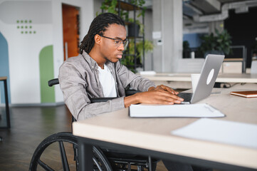 Dedicated student in wheelchair studying at laptop