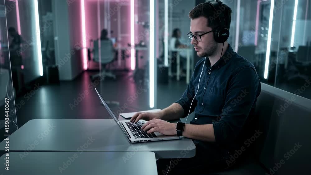 Poster man working on laptop. programmer or designer at a modern office with neon lights. software developm
