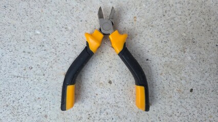 Essential hand tool for cutting wires and cables with ergonomic grip on stone surface. Wire cutters...