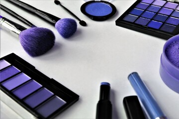 Makeup brushes, eye shadows and cosmetics on white background, closeup