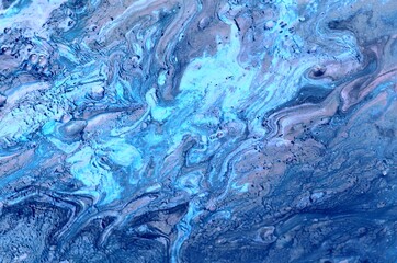 Marbled blue abstract background with golden sequins. Liquid marble ink pattern.