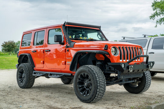 Mokane, MO, USA - July 13, 2025: Jeep Wrangler in Sahara trim with a customized front bumper and rock sliders at trailhead parking.