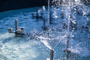 A close-up of a fountain jet forming a swirling cone of water, with dynamic splashes and droplets,...
