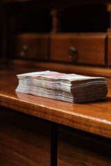 Stack of  banknotes on the wooden desk. Selective focus