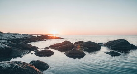 Stunning sunset over rocky shoreline with calm ocean waters