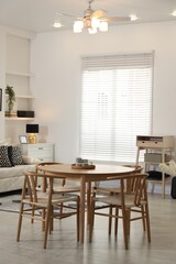 Table, chairs and comfortable sofa indoors. Interior design